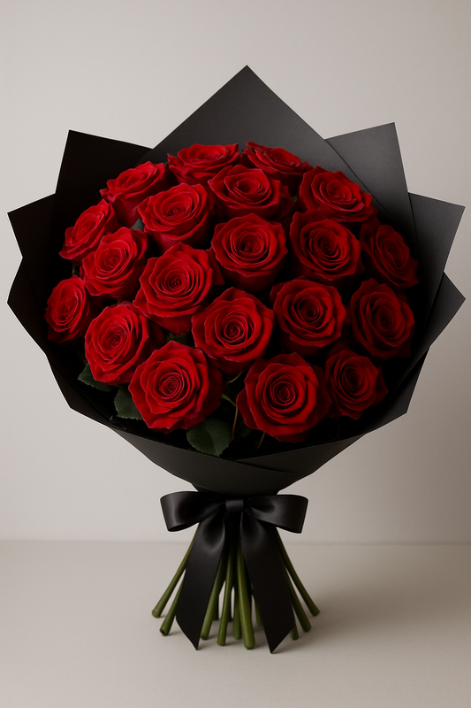 Red rose bouquet wrapped in black paper with satin ribbon.