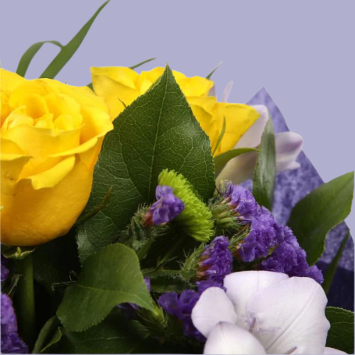 “Bouquet of yellow roses, lilac freesias, and purple flowers with greenery, wrapped in purple paper – under £35 UK flower delivery.”