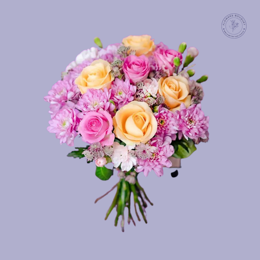 Elegant bouquet of pink and peach roses with chrysanthemums in a clear vase.