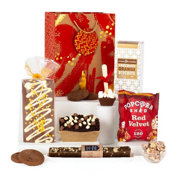 Festive chocolate orange and red velvet hamper with biscuits, fudge, popcorn, hot chocolate stirrer, and brownie in a holiday gift bag – UK winter gift box