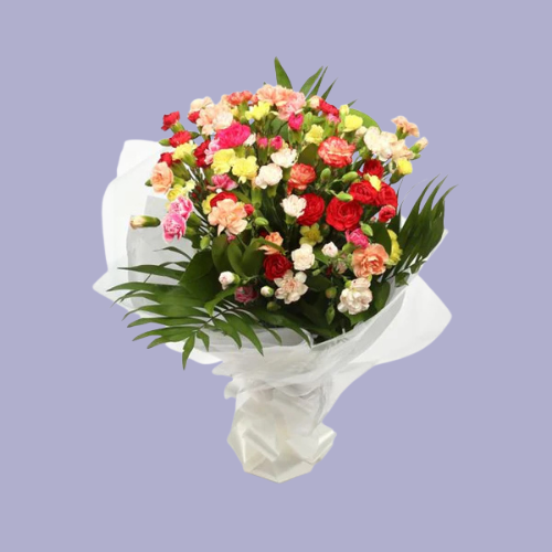 “Mixed carnation bouquet with red, pink, peach, and cream flowers combined with greenery, wrapped in white paper – affordable flowers under £35 UK.”