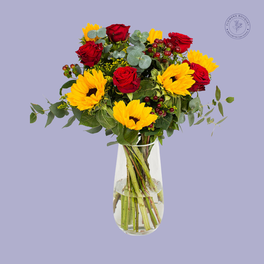 Bright bouquet of sunflowers and red roses with eucalyptus leaves and filler greenery.