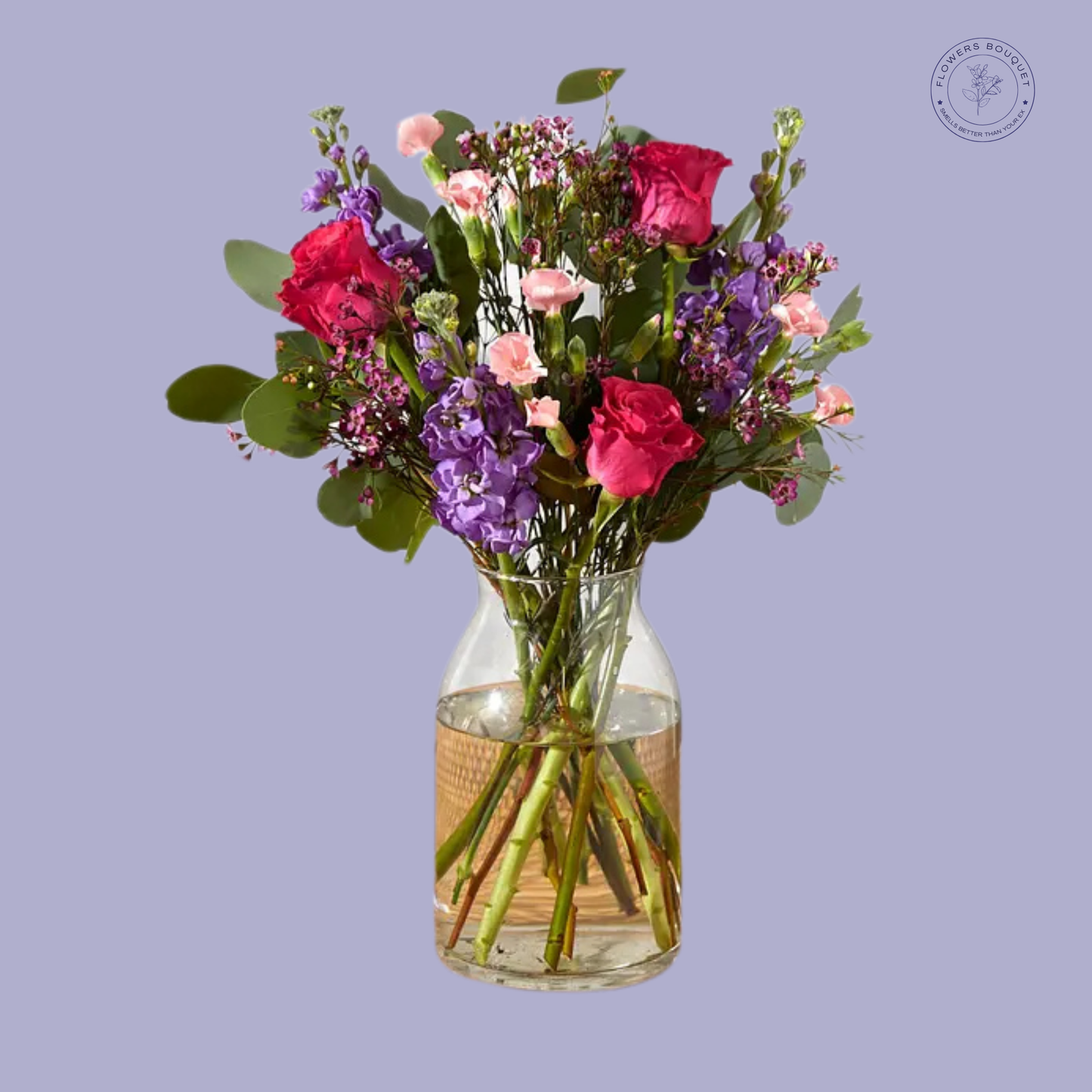 Twilight Bloom Arrangement featuring red roses, purple stock flowers, pink spray carnations, eucalyptus, and waxflowers in a glass vase.