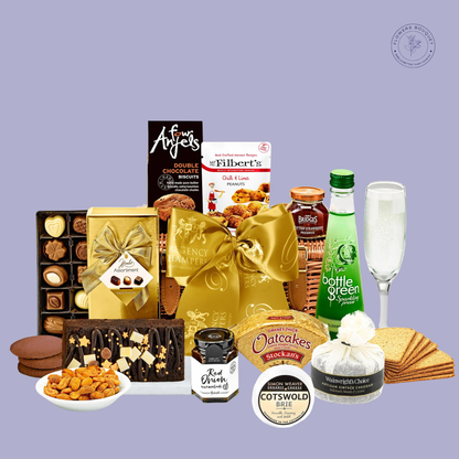A luxurious gift basket featuring sparkling elderflower pressé, double chocolate biscuits, oatcakes, assorted chocolates, preserves, cheese, and a festive chocolate loaf cake, wrapped with a golden ribbon.