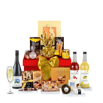 A regal red gift box featuring Luscombe pressés, premium chocolates, artisanal breadsticks, Yorkshire crisps, luxury fruitcake, and cheeses, wrapped with a golden ribbon.
