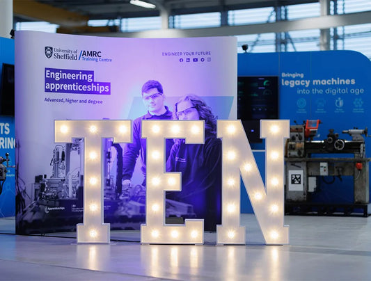 Custom white light-up letters spelling “TEN” at corporate apprenticeship event – illuminated signage hire for UK branding and business celebrations

