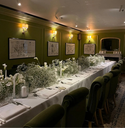 White Baby’s Breath and Calla Lily table arrangement with candles, perfect for elegant events and weddings.