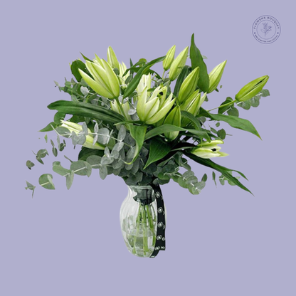  Elegant white lilies with eucalyptus leaves arranged in a premium bouquet.