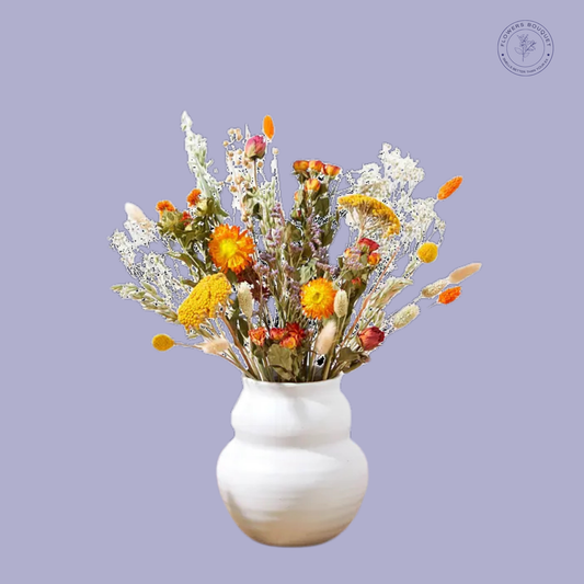 A charming dried flower arrangement called "Golden Glow," featuring craspedia, strawflowers, bunny tails, yellow achillea, and preserved white foliage in a ceramic vase.