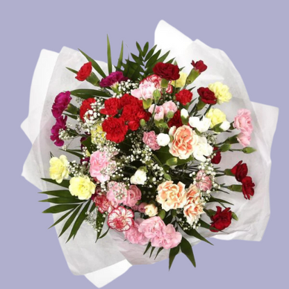 “Mixed carnation bouquet in pink, red, yellow, and peach tones with baby’s breath and greenery, wrapped in white paper – under £35 UK flowers.”