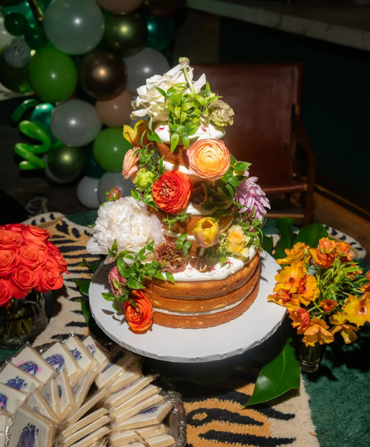 Modern bar decor with palm fronds, floral arrangement, champagne bottle, and stylish accessories, perfect for creating a tropical ambiance.