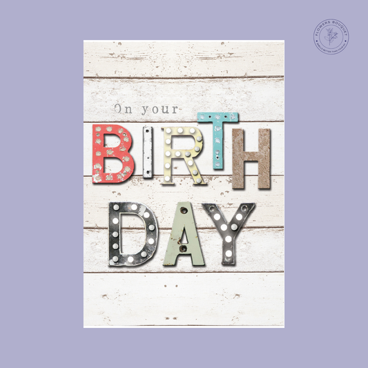 "On Your Birthday card with vintage light-up letters and rustic wood background."