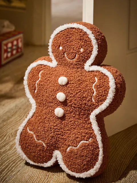 Plush gingerbread man Christmas decoration with white icing details and soft brown textured fabric