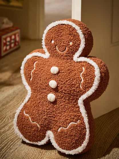 Plush gingerbread man Christmas decoration with white icing details and soft brown textured fabric