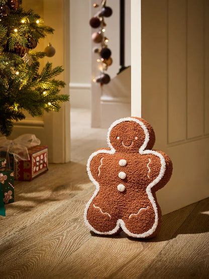Plush gingerbread man Christmas decoration with white icing details and soft brown textured fabric