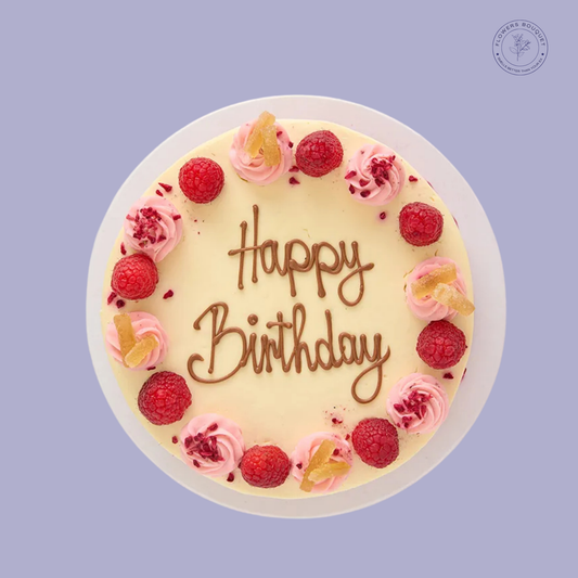 Raspberry & Lemon birthday cake with piped lemon buttercream, fresh raspberries, and candied lemon slices. Perfect for birthdays.