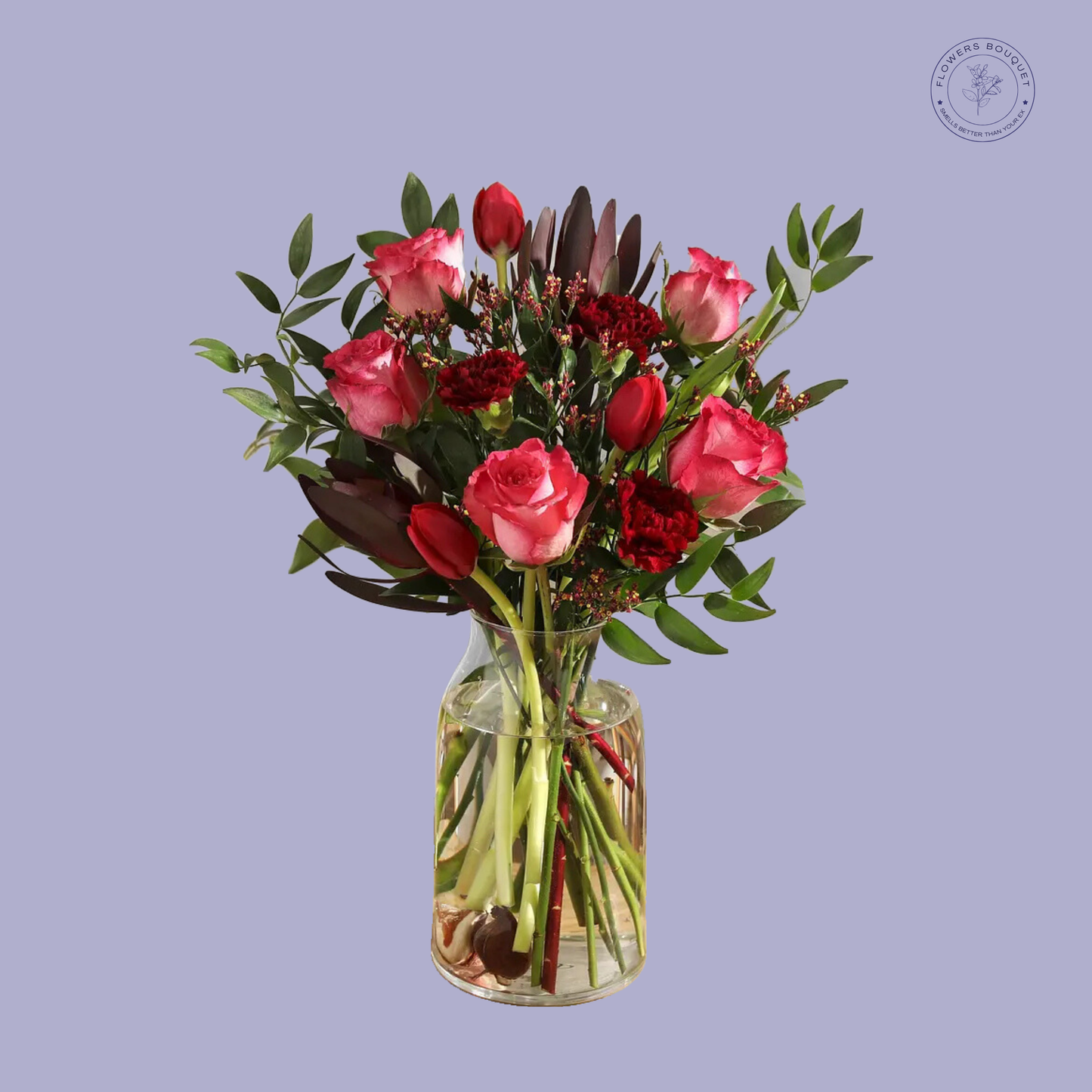 A luxurious floral arrangement called "Ruby Radiance," showcasing pink roses, deep red carnations, tulips, and lush greenery in a clear vase filled with water.