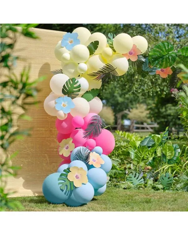 Tropical balloon garland arch with pastel balloons, floral accents, and tropical leaves for garden party decoration