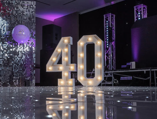 White light-up number 40 display on LED dance floor with stage lighting – illuminated event decor hire for UK milestone celebrations